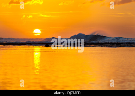 Sonnenuntergang mit hohen Wellen hinter dem Riff und ruhigem Wasser vorne am Ke'e Beach in Kauai, Hawaii. Stockfoto