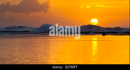 Sonnenuntergang mit hohen Wellen hinter dem Riff und ruhigem Wasser vorne am Ke'e Beach in Kauai, Hawaii. Stockfoto