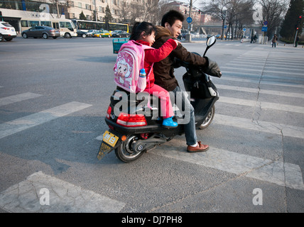 Vater und Tochter auf einem Roller in Peking, China Stockfoto