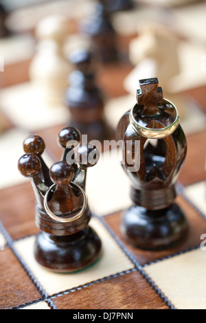 Trauringe und Schach Stockfoto