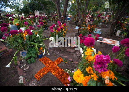 Ein Kreuz aus Ringelblumen schmückt ein Grab im Laufe des Tages der Toten in Teotitlan del Valle Friedhof, Oaxaca, Mexiko Stockfoto