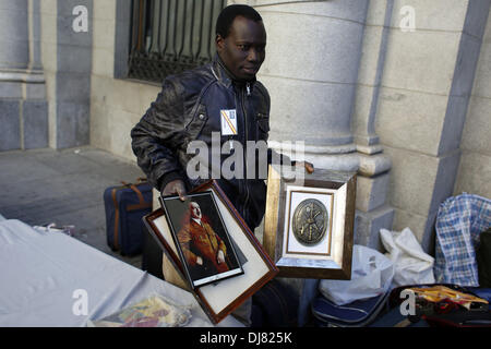 Madrid, Spanien. 24. November 2013. Mohamed, 33 Jahre alt, aus dem Senegal, setzt entfernt ein Bild des ehemaligen deutschen Führer Adolf Hitler als dem Stand wo er arbeitet temporäre Verkauf faschistischen und nationalsozialistischen waren nach dem Protest, der Tod von General Francisco Franco erinnert. Hunderte von Menschen Unterstützer der letzten spanischen Diktatur eine Kundgebung am Sonntag anlässlich des Todestages von Diktator Franco. Die Demonstration fand in Madrid der zentralen Plaza de Oriente.Photo: Rodrigo Garcia/NurPhoto Credit: Rodrigo Garcia/NurPhoto/ZUMAPRESS.com/Alamy Live News Stockfoto