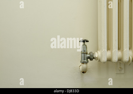 alten Stil altmodischen Konvektion Heizkörper ohne thermostatische Hitze Ventile nicht grün freundlich mit teilweise Leck am Wasserhahn Ventil Stockfoto