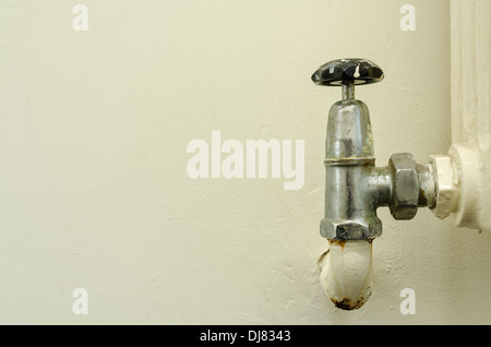 alten Stil altmodischen Konvektion Heizkörper ohne thermostatische Hitze Ventile nicht grün freundlich mit teilweise Leck am Wasserhahn Ventil Stockfoto