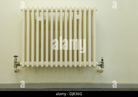 alten Stil altmodischen Konvektion Heizkörper ohne thermostatische Hitze Ventile nicht grün freundlich mit teilweise Leck am Wasserhahn Ventil Stockfoto