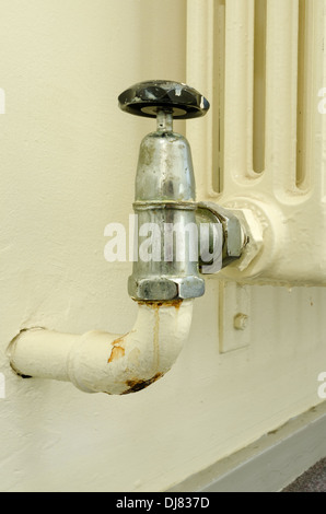 alten Stil altmodischen Konvektion Heizkörper ohne thermostatische Hitze Ventile nicht grün freundlich mit teilweise Leck am Wasserhahn Ventil Stockfoto