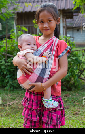 Lao junge Mädchen halten ihr Baby Bruder, Vang Vieng, Laos Stockfoto