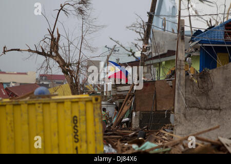 Bewohner von Tacloban City sind Links versuchen, alles zu retten, was sie, in der Nachmahd des Typhon Haiyan/Yolanda können. Viele sind wenn sie die vorübergehende Unterbringung für ihre Familien können, den Wiederaufbau. Nur die immense Menge an Schmutz zu entfernen, ist eine enorme Aufgabe. Die philippinische Flagge symbolisiert hier die Kraft und den Geist der lokalen Gemeinschaft. Stockfoto