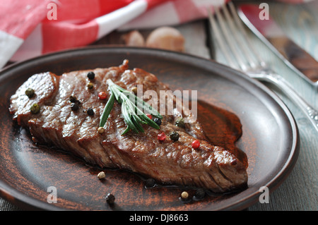 Gegrilltes Steak auf dem Teller mit Tomaten, Gewürze und Rosmarin closeup Stockfoto