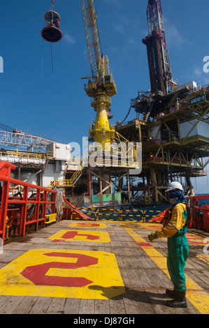 Schiffsmatrosen oder Schiffsbesatzungen, die an Deck für den Transfer der Plattformbesatzung mit einem Sicherheitskorb arbeiten Stockfoto