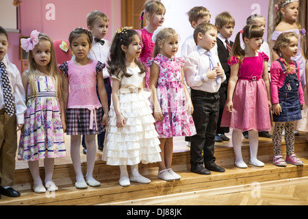 Russische Kinder Kindergarten. Kinder tanzen mit Sonnenschirmen auf der