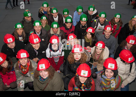 London, 24. November 2013. Demonstranten in rot gekleidet und grüne Bergleute Helme zusammenstehen während ihrer laufenden Serie von Protesten gegen die umstrittene vorgeschlagenen Goldmine in Rosia Montana in Siebenbürgen. Bildnachweis: Paul Davey/Alamy Live-Nachrichten Stockfoto