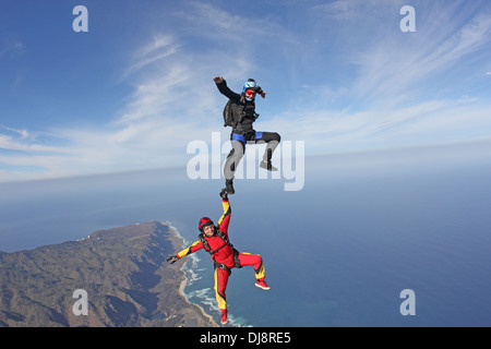 Fallschirmspringer-Paare sind Kopf fliegen innerhalb einer Teambildung. Ein Jumper hält das andere auf den Schuh und seinen Spaß haben. Stockfoto