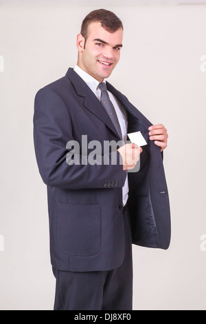 Lächelnde Geschäftsmann nimmt eine Visitenkarte aus seiner Jacke Stockfoto
