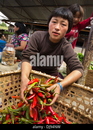 Bhutan, Nobding, Frau mit Handvoll heiße rote und grüne Chilis im Markt Stockfoto