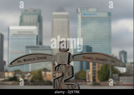 National Cycle Network Meilenstein außerhalb der O2 mit Canary Wharf Wolkenkratzern im Hintergrund, East London Stockfoto