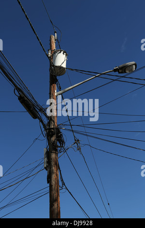 Stromleitungen, Transformator und hängenden Metall Laterne an Holzstab befestigt. Stockfoto