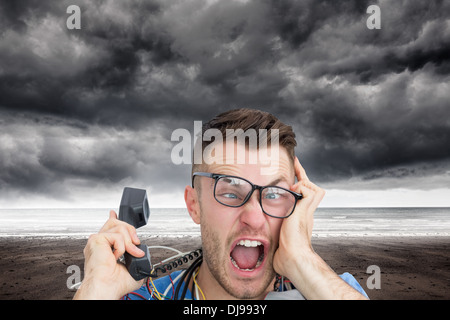 Zusammengesetztes Bild von frustriert Computer-Ingenieur schreien während bei Anruf vor der offenen cpu Stockfoto