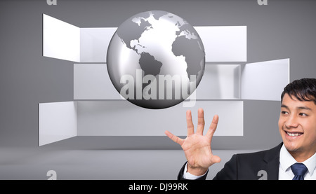 Zusammengesetztes Bild des lächelnden Geschäftsmann halten und zeigen Stockfoto