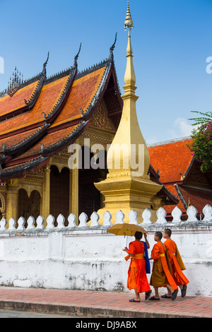 Jungen Novizen gehen vorbei an Wat Sop in Luang Prabang, Laos Stockfoto