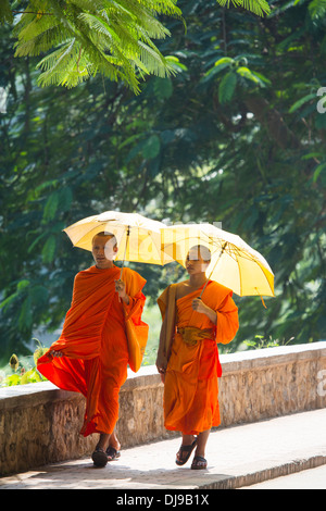 Jungen Novizen Fuß am Ufer des Nam Khan River in Luang Prabang, Laos Stockfoto