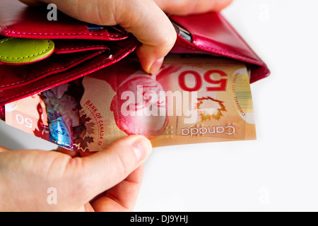 Menschliche Hand ziehen Geld aus der Brieftasche kanadischen Brieftasche mit kanadischen Geld. Stockfoto