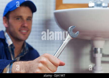 Schöne fröhliche Klempner mit Schraubenschlüssel Stockfoto