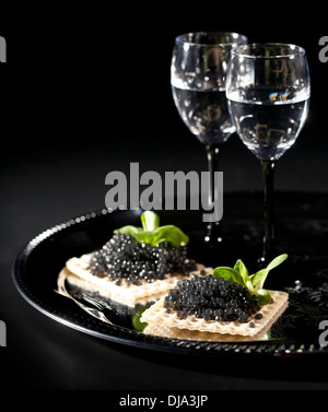 Wodka und schwarzen Kaviar auf schwarzem Hintergrund Stockfoto