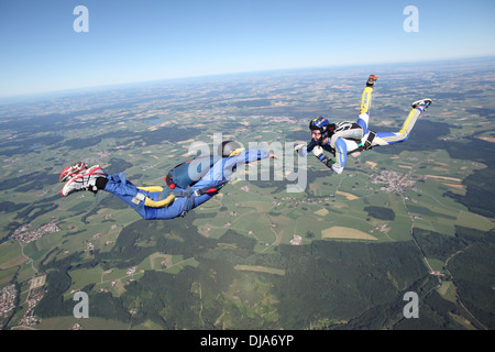 Fallschirmspringer springen Lehrer steuert den Schüler im freien Fall während eines Fluges über schöne Landschaft. Stockfoto