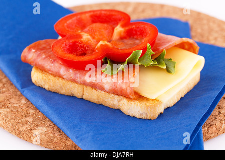 Sandwich mit blauen Serviette auf braunen runden Brett. Stockfoto