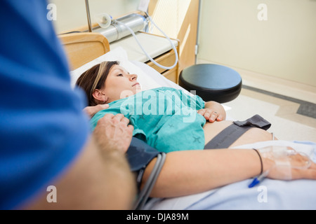 Die Hand des Menschen trösten schwangere Frau am Krankenhausbett liegen Stockfoto