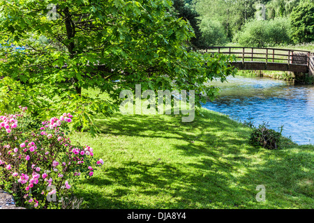 Blick über den Fluss Coln und ziemlich Holzsteg in Bibury in den Cotswolds. Stockfoto