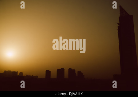 Die Sonne geht hinter einer dicken Schicht von Sand in den Horizont in der Dubai Media City. Dubai, Vereinigte Arabische Emirate. Stockfoto