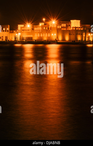 Das historische Bastakiya Viertel in Dubai spiegelt die Lichter auf dem Creek in der Nacht. Dubai, Vereinigte Arabische Emirate. Stockfoto