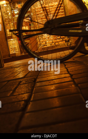 Ein Fahrrad geht durch die Schaufenster von einem Juwelier in Deira Gold Souk in der Nacht. Dubai, Vereinigte Arabische Emirate. Stockfoto