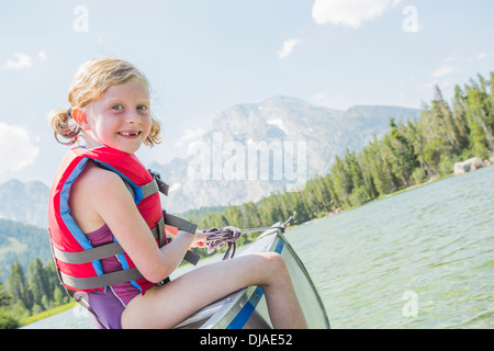 Kaukasische Mädchen sitzen im Kanu auf See Stockfoto