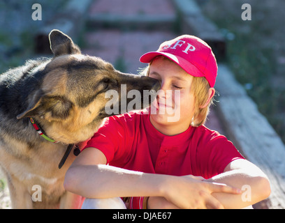 Hund leckt kaukasischen jungen Gesicht Stockfoto
