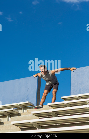 Hispanic Athleten Dehnung auf Tribüne Stockfoto