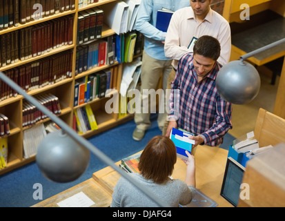 Ältere Studierende am Schalter im College-Bibliothek Stockfoto