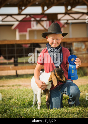 Kaukasische junge mit Preis gewinnende Ziege auf Bauernhof Stockfoto