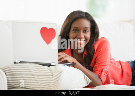 Schwarze Frau mit Laptop auf sofa Stockfoto