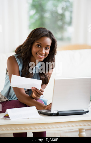 Schwarze Frau Rechnungen online bezahlen Stockfoto