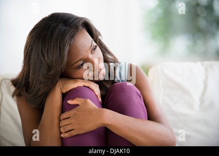 Schwarze Frau umarmt die Knien Stockfoto