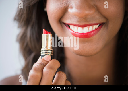 Schwarze Frau halten Lippenstift Stockfoto