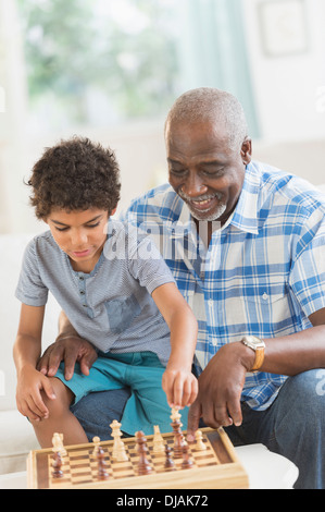 Junge spielt Schach mit Großvater Stockfoto