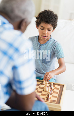 Junge spielt Schach mit Großvater Stockfoto