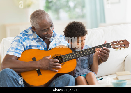Junge Gitarre spielen mit Großvater Stockfoto