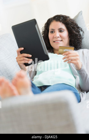 Hispanic Frau mit digital-Tablette auf sofa Stockfoto