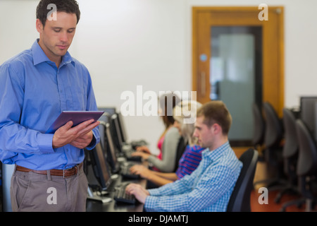 Lehrer mit Schülern, die mit dem Computer im Computerraum Stockfoto