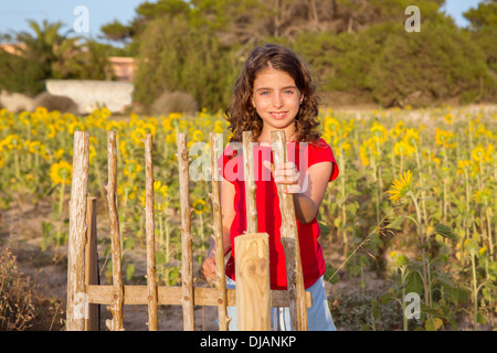 Lächelnder Bauernmädchen mit Sonnenblumen Feld Zaun Tür im Mittelmeer Stockfoto